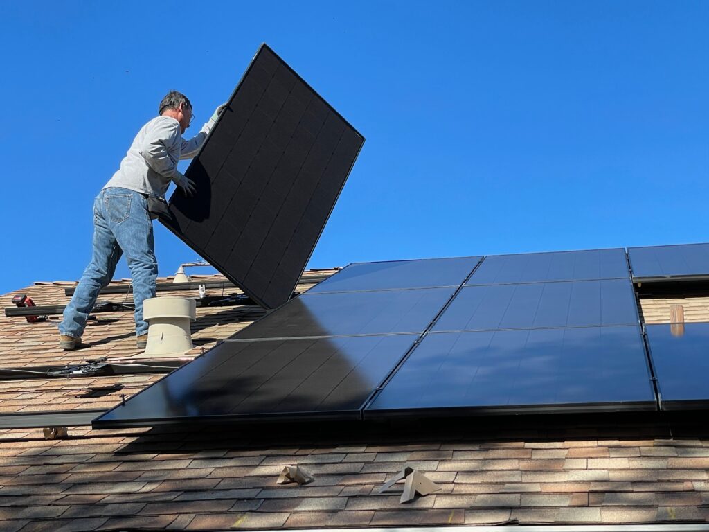 A man installing one of the best ways to make your Texas home more eco-friendly, the solar panels.